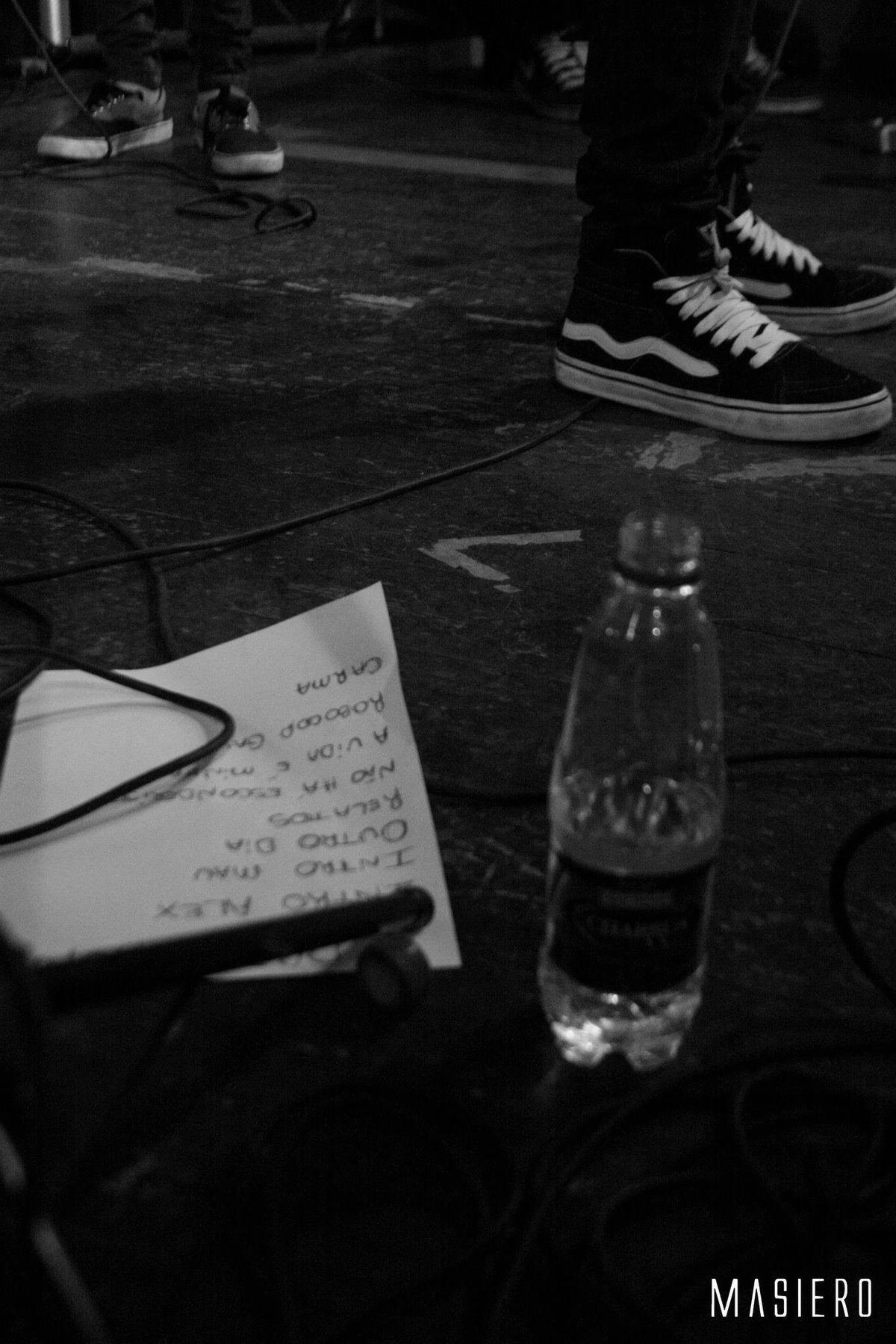 Tênis, garrafa d'água e o setlist no chão do palco.