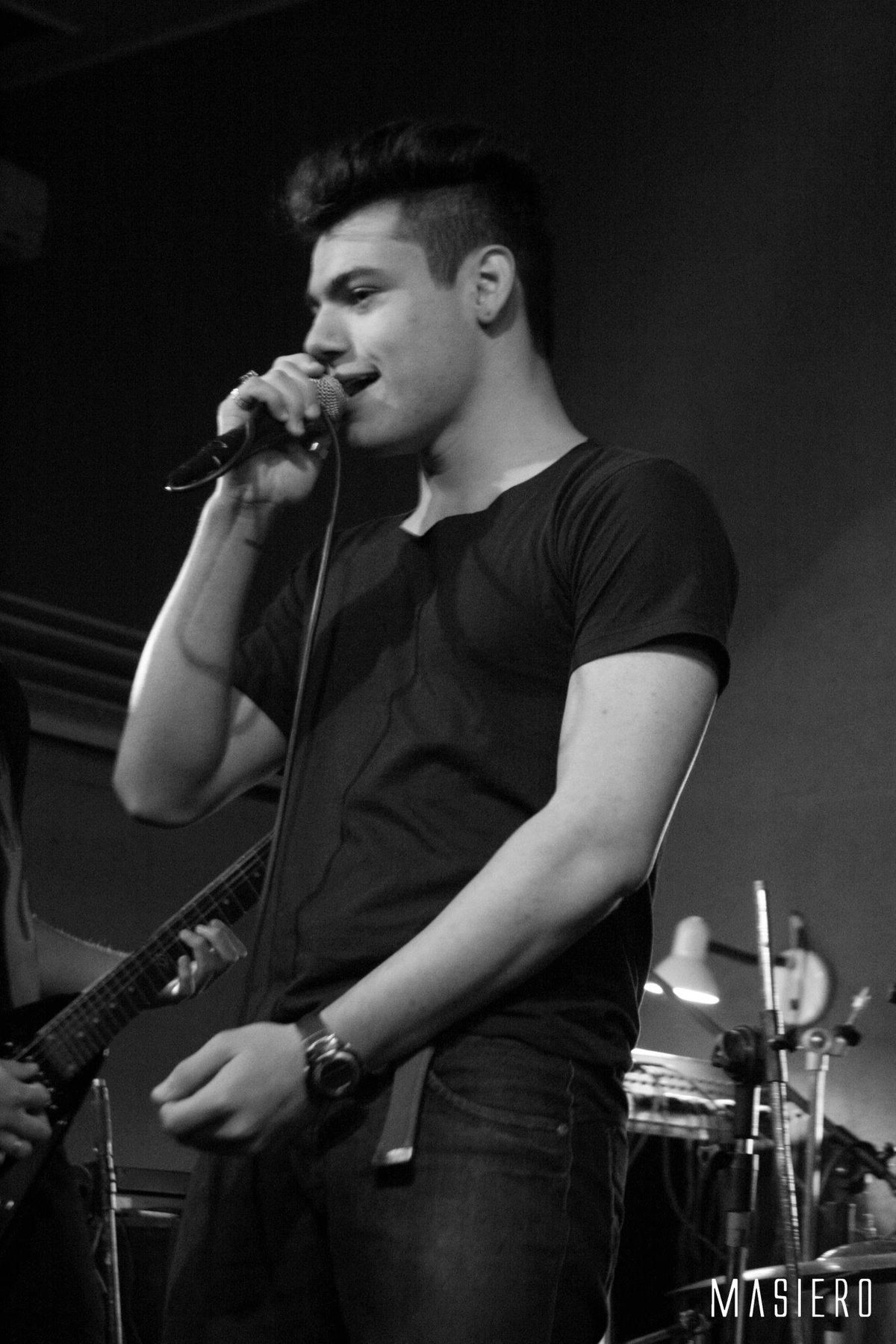Vocalista cantando no palco, em preto e branco.