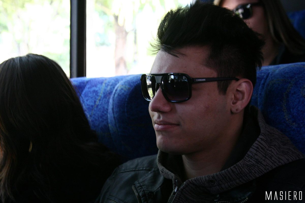Integrante de óculos escuros no ônibus.